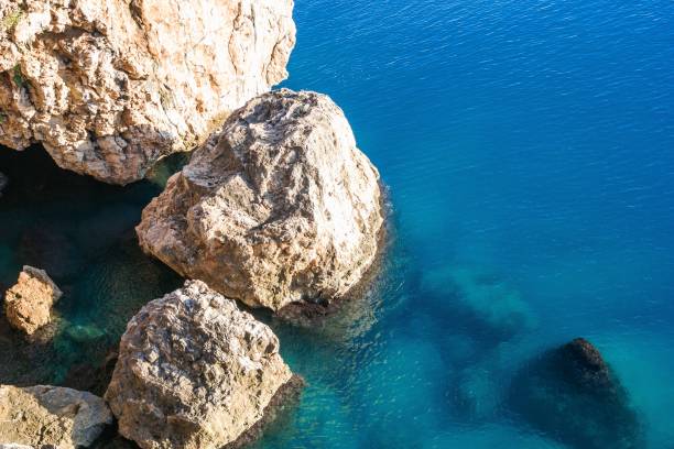 Tranquil beach scene with azure waters and unique rock formations under a bright sun