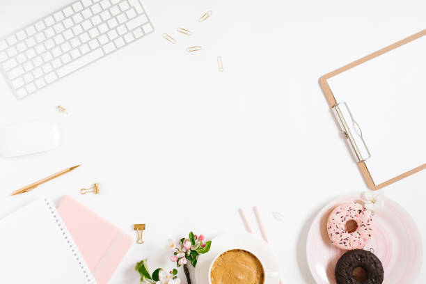istock Trendy stylish frame for a female blogger, freelancer: notebooks, tablet, keyboard, donut on a plate, apple blossoms on a white background with a place to copy 2027211140