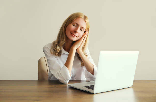 istock Tired overworked sleeping woman employee while working with laptop in office 2027211150