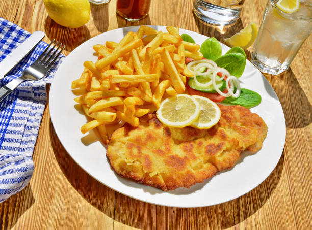 Schnitzel with French Fries on wooden Background; Meat specialty and popular fine food