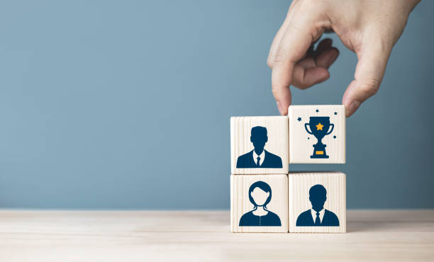 istock Quality testing and evaluation excellent employees. Square wooden block with human icon and trophy. 2027226166