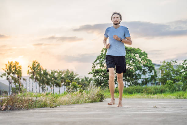 istock A man runner is engaged in jogging on a concrete path without shoes, without sneakers, for health 2027250418