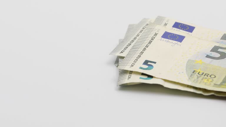 Putting on the white table banknotes of 5 euros. White background