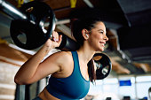 Happy female athlete having strength training in a gym.