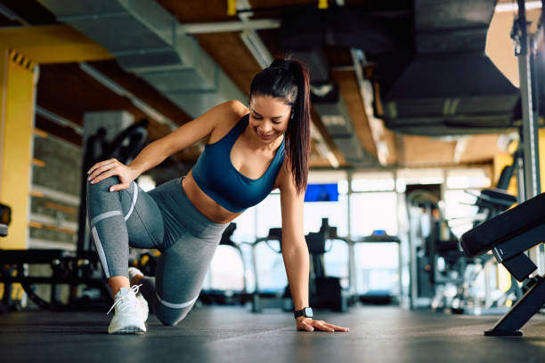 istock Happy sportswoman doing stretching exercises while working out in heath club. 2027280501
