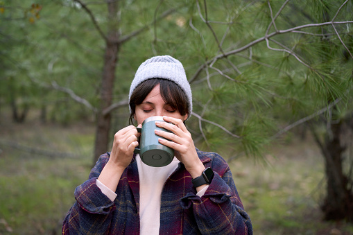 Young female enjoying her cup of coffee outdoors