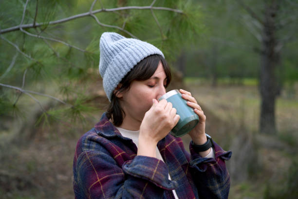 istock Beautiful Woman Drinking Coffee in Nature 2027340595