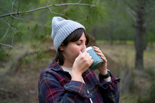 Young female enjoying her cup of coffee outdoors