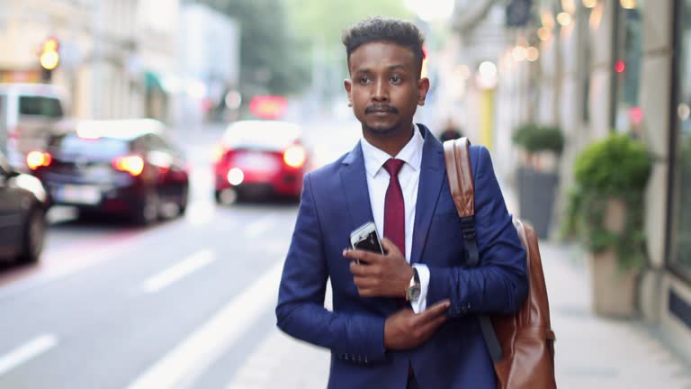 Indian/Pakistani businessman using mobile phone while commuting to/from work