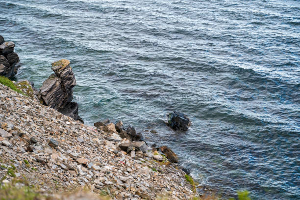 Rocky seashore with stones on a steep slope
