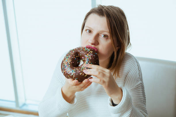 istock Beautiful woman eating chocolate donut 2027366713