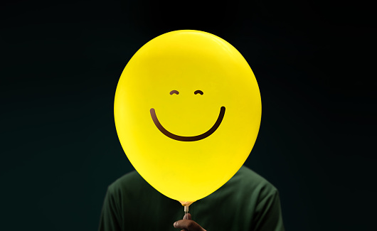 Happiness Day Concept. Happy and Optimistic Mind, Well Mental Health. Enjoying Life Everyday. Happiness Person with a Smiling Emoticon Balloon