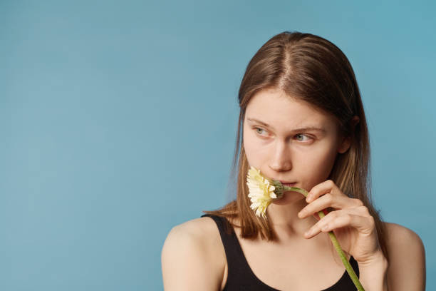 young woman with flower - flower sparse single flower gerbera daisy ストックフォトと画像