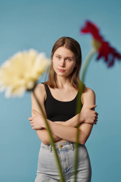 istock Young Woman And Flowers Studio Portrait 2027398489