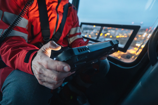 Close-up of hands of doctor inside helicopter emergency medical service while using digital tablet during a night mission flight.