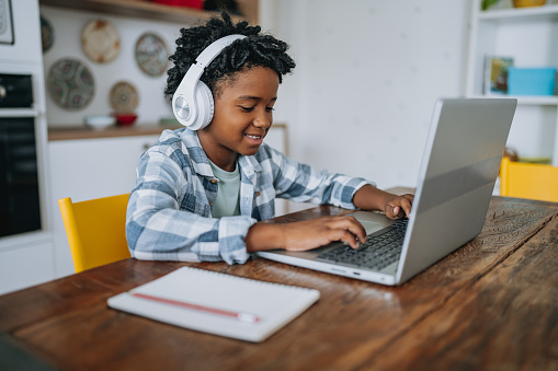 Portrait child boy studying at home on laptop