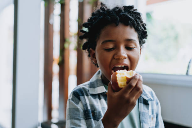 istock Portrait child boy eating apple at home 2027421047