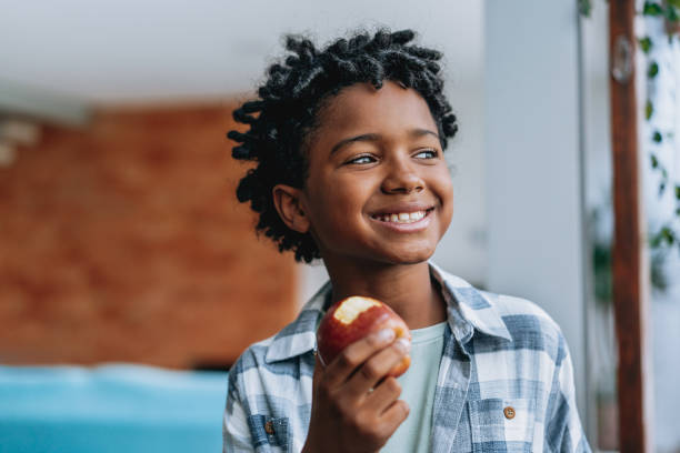 Portrait child boy eating apple at home
