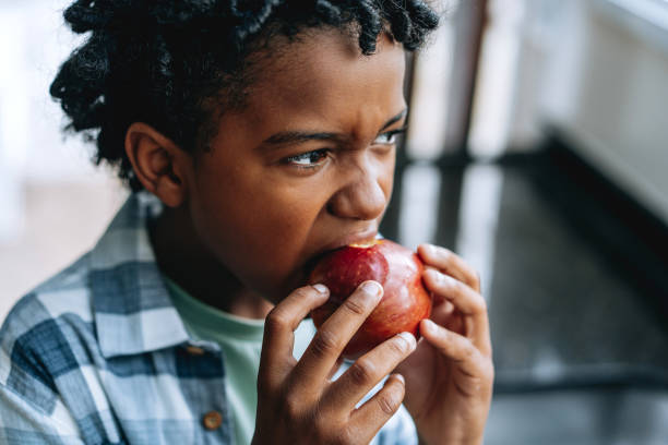 istock Portrait child boy eating apple at home 2027421556