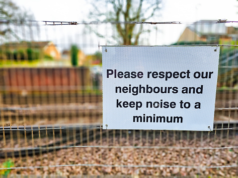 A sign on a city street asking people to respect the neighbours and keep noise to a minimum.