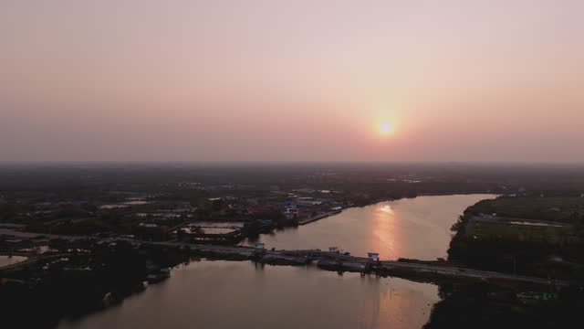 Drone shots of the beauty of the Bang Pakong River in the evening as the sun sets. Villagers living along the waterfront in Chachoengsao Province