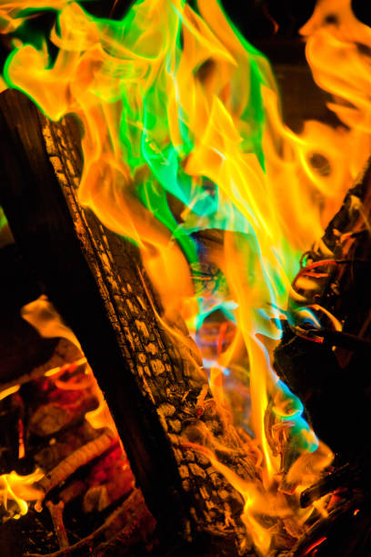 Vibrant and mesmerizing, this close-up captures a wood fire ablaze with golden yellow flames. Unexpected patches of green and blue add a touch of mystery to the intense heat. Perfect for energy, warmth, and elemental-themed projects.