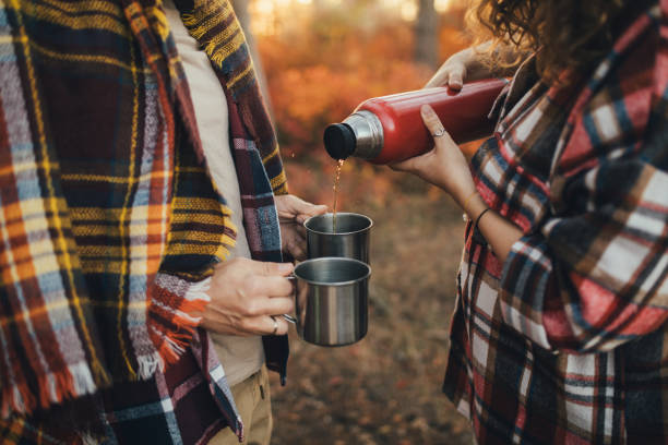 istock Happy couple drinking tea from thermos in an autumn forest. 2027474658
