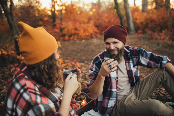 istock Happy couple drinking tea from thermos in an autumn forest. 2027474671