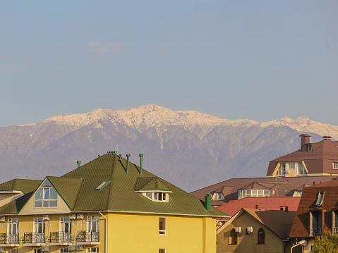 Colorful houses and snow capped mountains in the background, Sochi, Russia