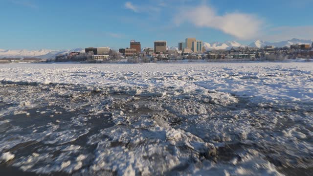 Frozen waterway with Downtown Anchorage skylines in the background, Alaska, USA