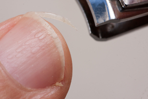 Close up of a person trimming their finger nails