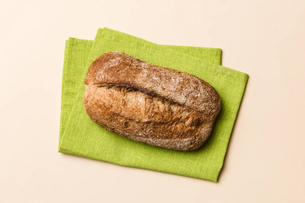 istock Fresh Homemade Whole Wheat Bread. bread on napkin on rustic background, fresh bread top view 2027565688