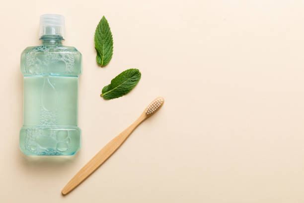 istock Mouthwash and fresh mint on colored background, top view with copy space for text 2027566777