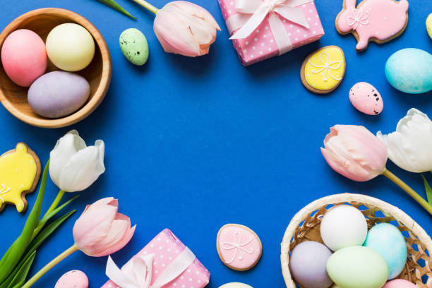 istock Easter frame with eggs, gift box and tulip on a colored background. The minimal concept. Top view Happy Easter composition. Card with a copy space of the place for the text 2027566780