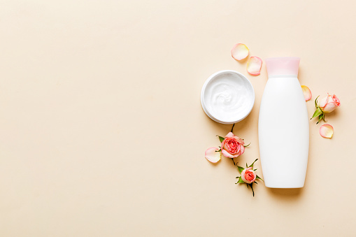 Fancy healthcare bottles for cream with rose flower. Natural oranic spa cosmetics concept. Mockup, template, Top view.