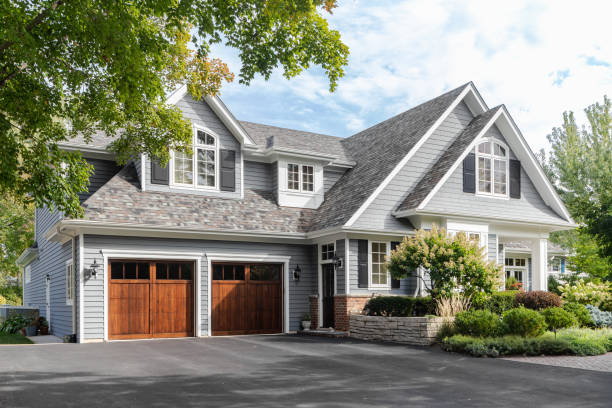 A grey and white modern farmhouse. Naperville, IL, USA - A large grey and white modern farmhouse with two wooden garage doors, and beautiful landscaping. empty home garage stock pictures, royalty-free photos & images