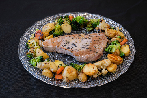 Freshly grilled tuna steak with vegetables on glass plat