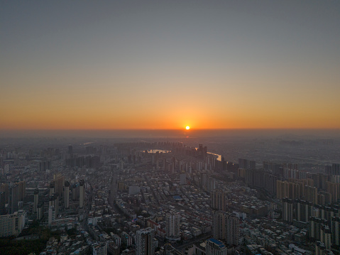 A bird's-eye view of the sun shining on modern cities and stocks