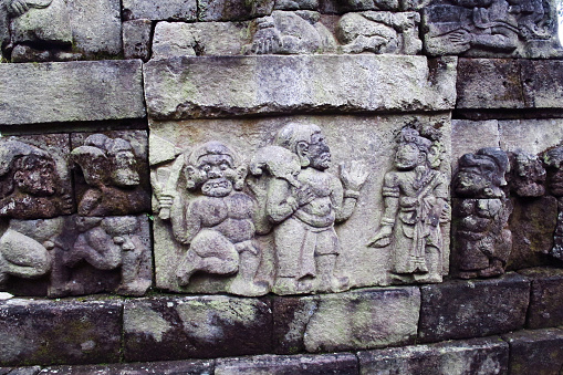 Bas-relief sculptures on wall at encased foot of Sukuh Temple, ancient historical heritage site in central Java  - Indonesia
