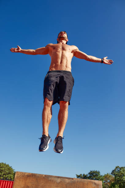 istock Sporty physically fit man doing step-up exercise on wooden box while doing gym training outdoor. 2027606016