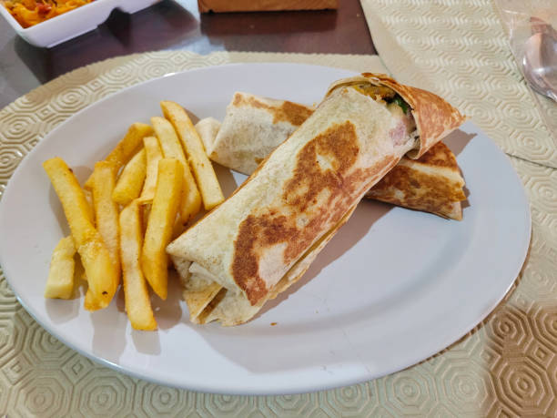 istock Grilled Wrap with French Fries on a White Plate 2027610314