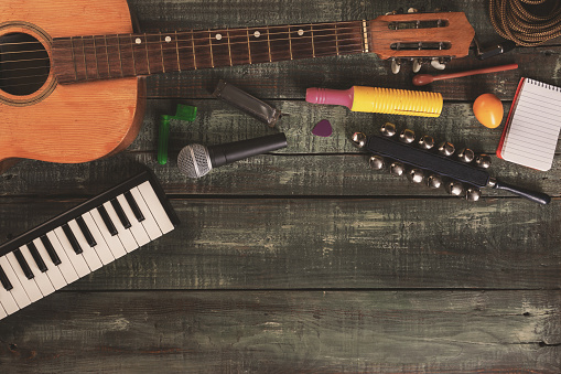 Music and musician background with copy space for ads and banners - Diverse musical instruments and recording gear arranged on a wooden surface - Essential tools for music creation