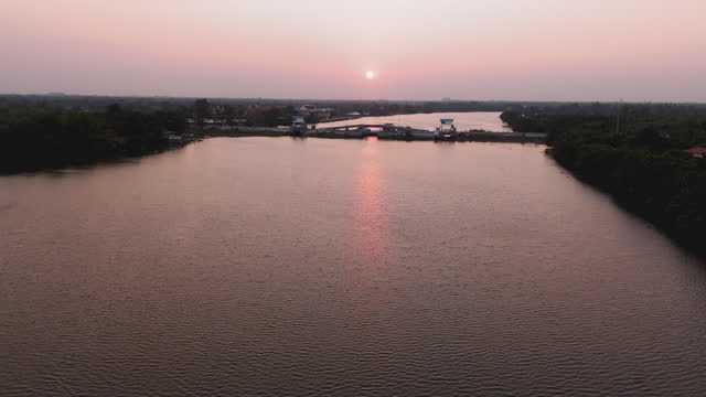 Drone shots of the beauty of the Bang Pakong River in the evening as the sun sets. Villagers living along the waterfront in Chachoengsao Province