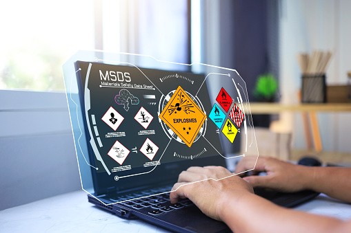 Material safety data sheet MSDS with staff on laptop computer to down load dangerous chemical information from cloud to study working hazardous substance such as explosives, flammable gas, oxidizer