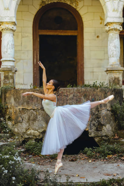 istock Prima ballerina is making beautiful figure in front of a rustic building. 2027636614
