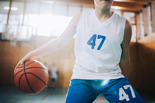 Cute teenage girls, smiling and hugging after basketball match, happy after winning the game