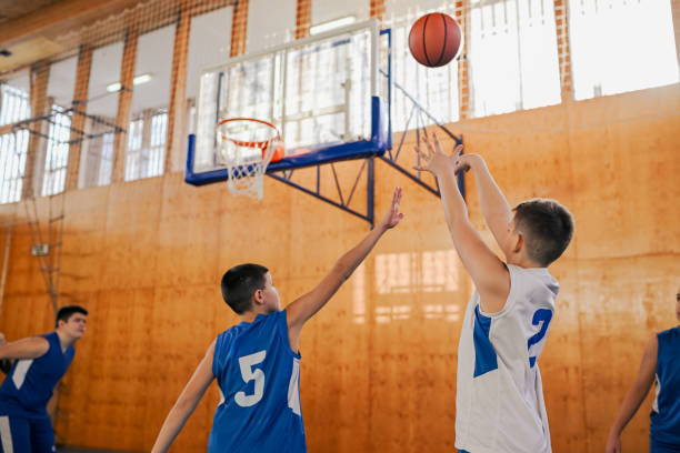 istock Junior basketball player is shooting at the hoop on training with team. 2027637158
