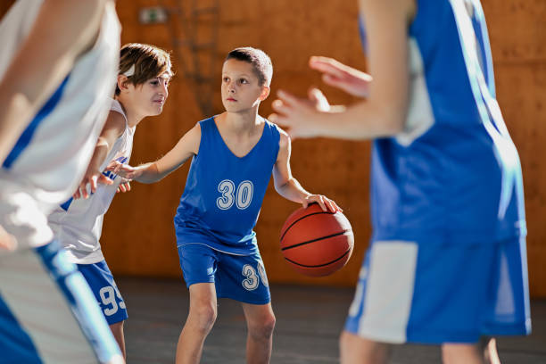 istock Basketball kid is dribbling and guarding a ball during training with team. 2027637168
