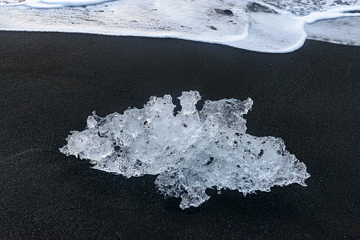 Ice shape washed up on the black ash beach known as Diamond Beach at Jokulsarlon, Iceland