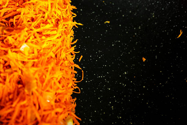cook fresh raw carrots cut into pieces in a frying pan. view from above